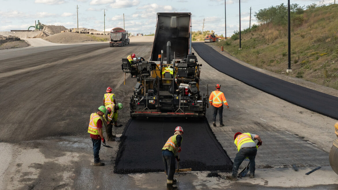 Harvest Green's biomass pyrolysis system and crew laying asphalt.